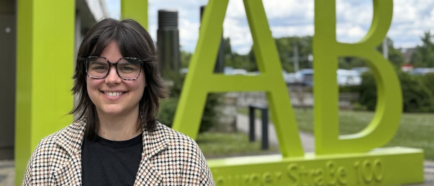 Johanna Mauer, Volontärin am IAB, steht vor dem IAB-Gebäude.